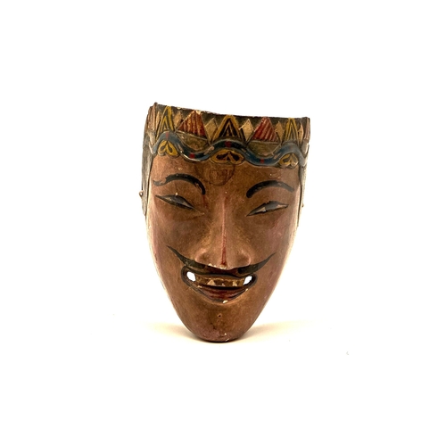 25 - A carved and painted mask. Possibly from Asia and theatrical 