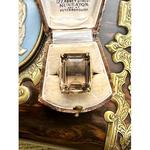 145 - A single stone trap cut smokey quartz dress ring in an all yellow metal unmarked mount testing for 1... 