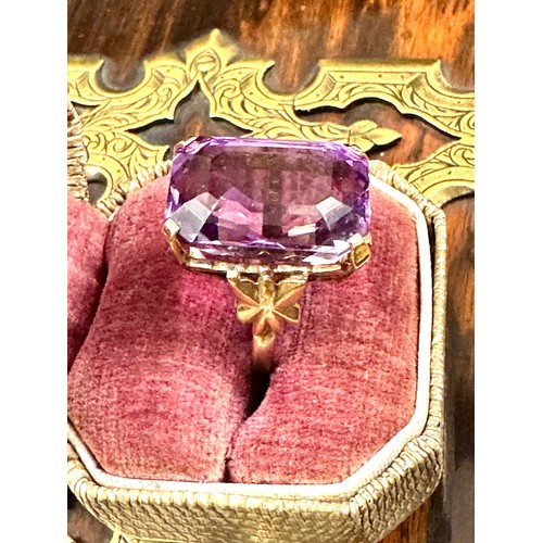 143 - A single stone trap cut amethyst dress ring in a 9ct yellow gold hallmarked mount. The stone measure... 