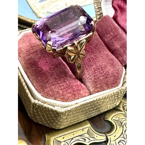 143 - A single stone trap cut amethyst dress ring in a 9ct yellow gold hallmarked mount. The stone measure... 