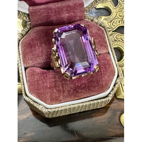 143 - A single stone trap cut amethyst dress ring in a 9ct yellow gold hallmarked mount. The stone measure... 