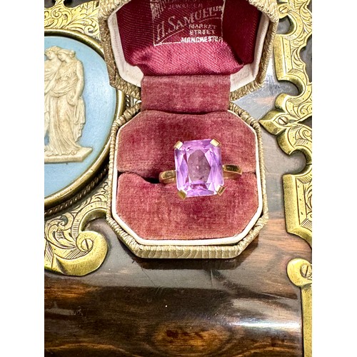 144 - A single stone trap cut amethyst dress ring in a 9ct yellow gold hallmarked plain four claw mount. T... 