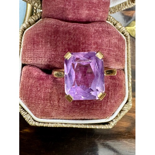 144 - A single stone trap cut amethyst dress ring in a 9ct yellow gold hallmarked plain four claw mount. T... 