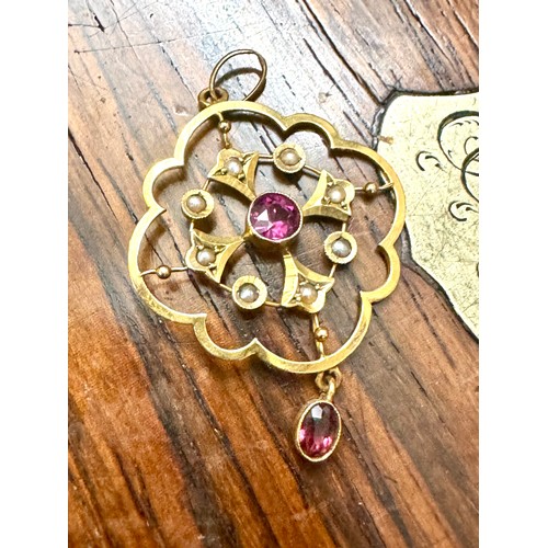 147 - An amethyst and half pearl pendant in an all yellow metal mount stamped '9ct'. A central round facet... 