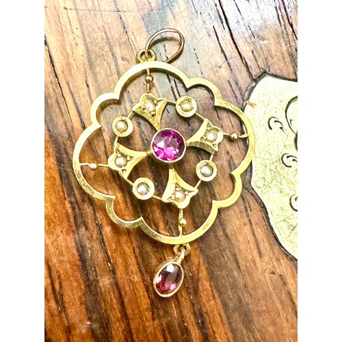 147 - An amethyst and half pearl pendant in an all yellow metal mount stamped '9ct'. A central round facet... 