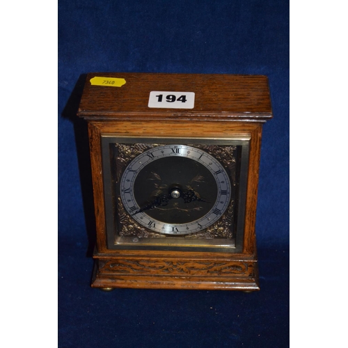 194 - ELLIOTT MANTLE CLOCK IN OAK CASE WITH BLIND FRETWORK DECORATION, ON BRASS BALL FEET