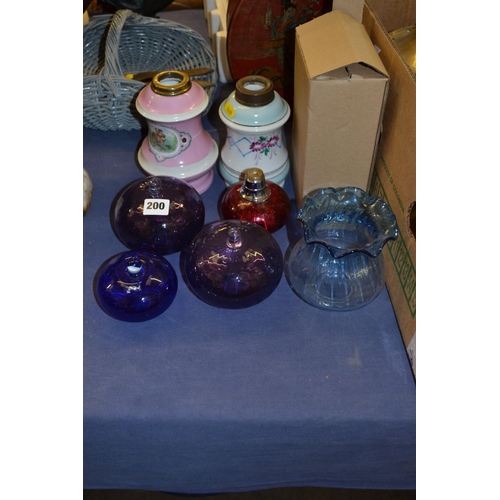 200 - TWO CONTINENTAL PORCELAIN OIL LAMP RESERVOIRS, 4 GLASS OIL LAMP RESERVOIRS, SHADE AND CHIMNIES