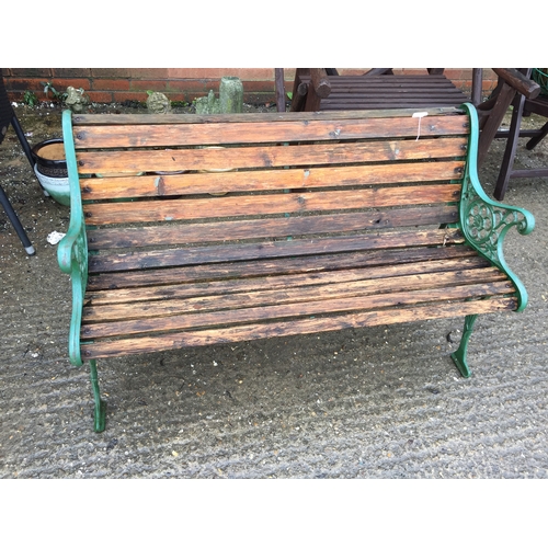 653 - WOODEN SLATTED GARDEN BENCH WITH CAST IRON ENDS