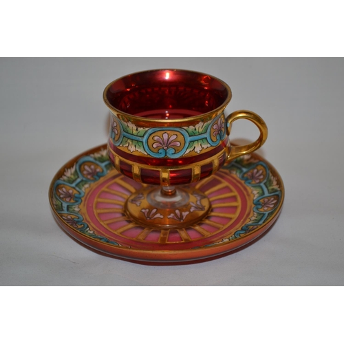 55 - C1900 MOSER CRANBERRY GLASS TEACUP AND SAUCER WITH GOLD AND ENAMEL DECORATION