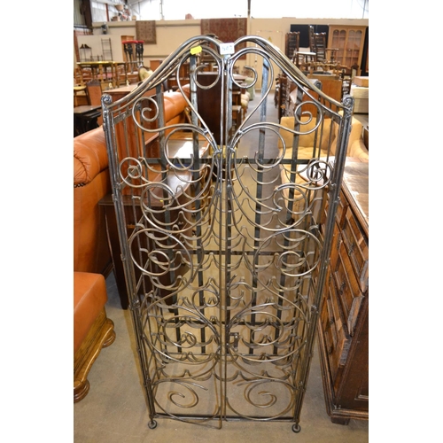 543 - WROUGHT IRON FREE STANDING 50 BOTTLE WINE RACK ENCLOSED BY PAIR OF ORNATE DOORS