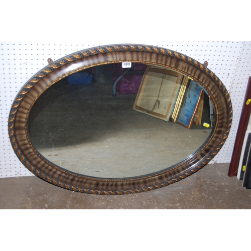 489 - EDWARDIAN OVAL WALL  MIRROR IN OAK LEAF DECORATED FRAME