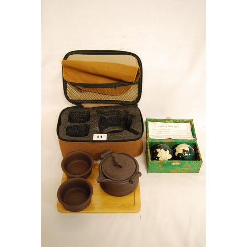 11 - BROWN EARTHENWARE JAPANESE SAKE SET & TRAY IN CASE AND PAIR OF MUSICAL CHINESE IRON STRESS BALLS