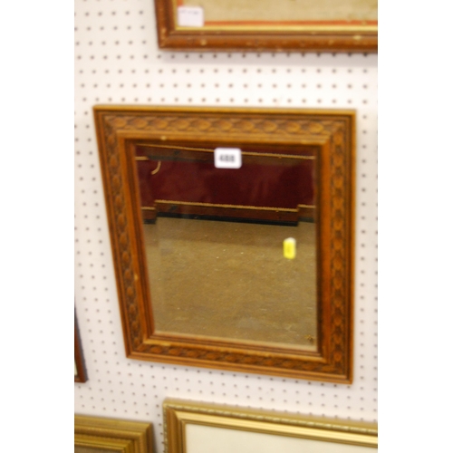 488 - BEVELLED GLASS WALL MIRROR IN CARVED OAK FRAME