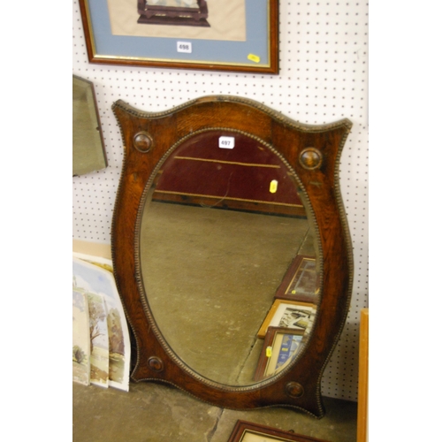 497 - EDWARDIAN OVAL BEVELLED WALL MIRROR IN SHAPED OAK FRAME