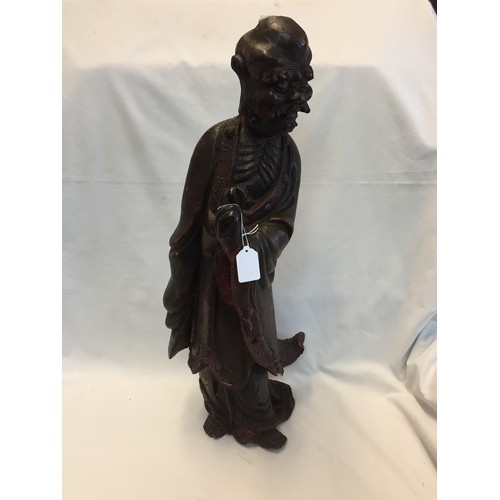 125 - 19TH CENTURY CARVED AND PAINTED WOOD FIGURE OF OLD MAN IN ROBES HOLDING AN EGG (60cm)