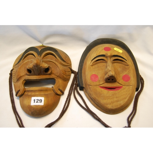 129 - 2 ORIENTAL CARVED WOOD FACE MASKS