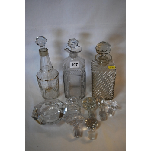 107 - THREE 19TH CENTURY GLASS DECANTERS & VARIOUS STOPPERS