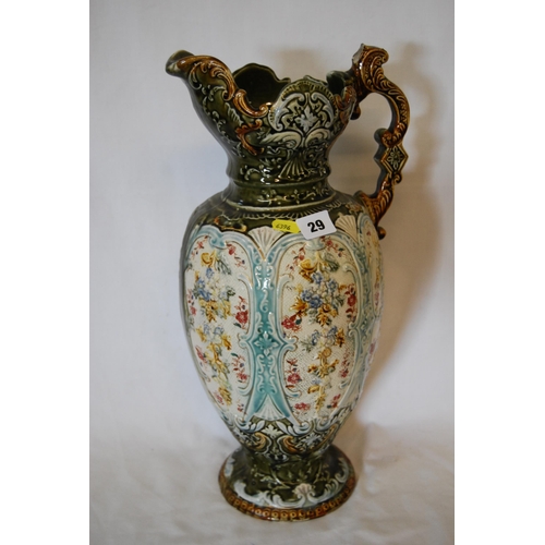 29 - CONTINENTAL MAJOLICA EWER EMBOSSED WITH FLORAL PANELS, SCROLL HANDLE & SHAPED RIM (46cm)