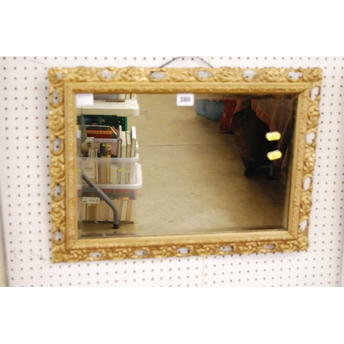 380 - BEVELLED WALL MIRROR IN ORNATE GILT FRAME (55cm x 40cm)