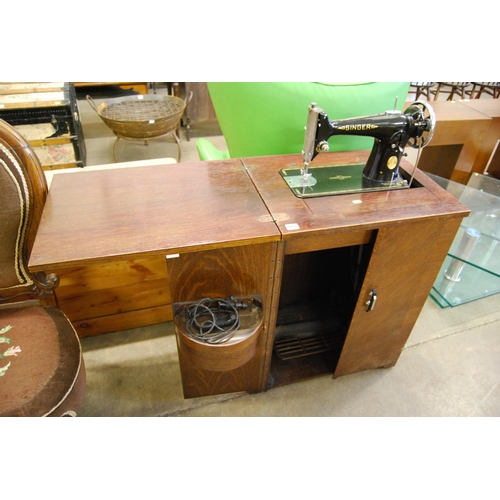 479 - SINGER TREADLE SEWING MACHINE IN OAK CABINET