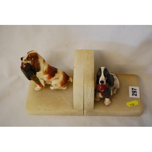 297 - PAIR OF MARBLE BOOKENDS SURMOUNTED WITH CERAMIC SPANIELS CARRYING PHEASANTS (1 A/F)