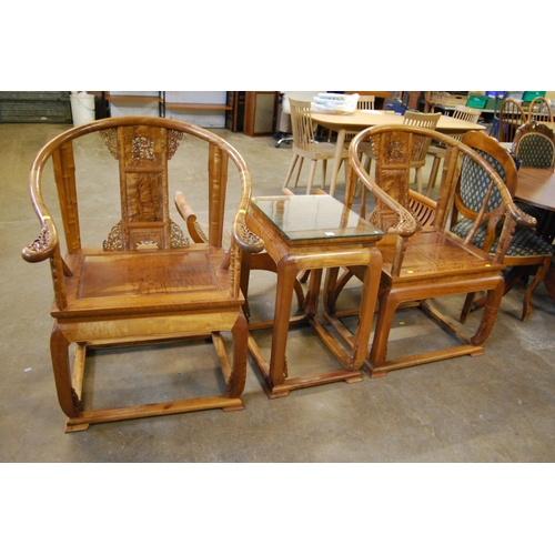 414 - PAIR OF ORIENTAL CARVED TEAK HORSESHOE OPEN ARM ARMCHAIRS AND MATCHING TABLE