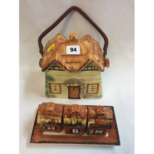 94 - THATCHED COTTAGE CHINA BISCUIT BARREL AND PRICE BROS COTTAGE CRUET SET ON TRAY