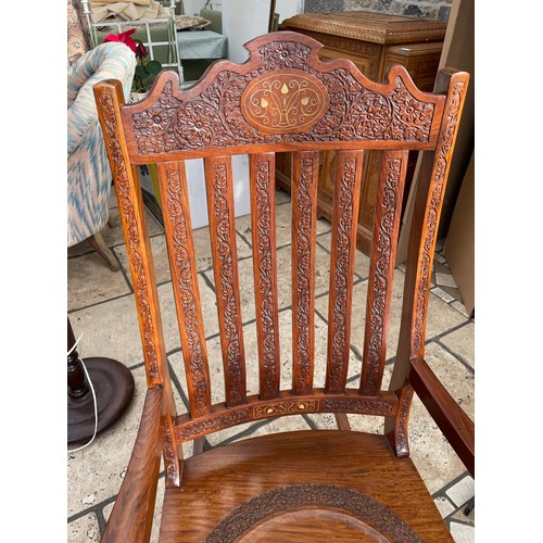 49 - Heavily carved brass inlaid rocking chair, seat height `16'' x 24''w