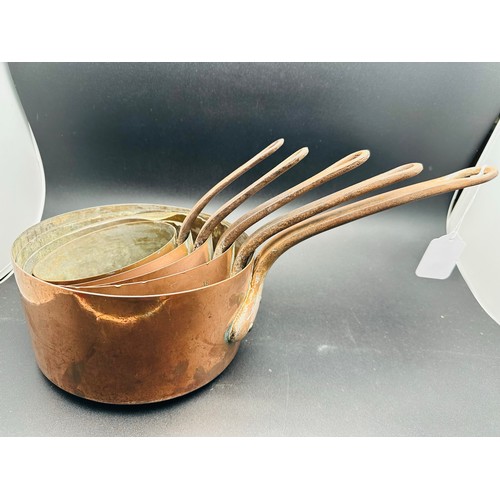 76 - A set of 5 graduated copper saucepans with iron handles