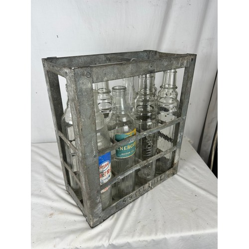 471 - A collection of 8 vintage embossed oil bottles with carry crate