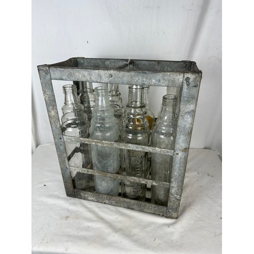 471 - A collection of 8 vintage embossed oil bottles with carry crate