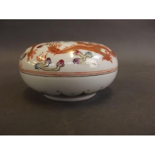 16 - A Chinese circular porcelain box and cover decorated in bright enamels with dragons chasing the flam... 