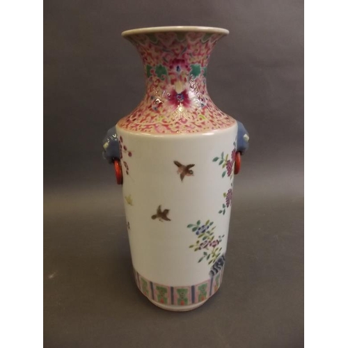 18 - A Chinese porcelain cylindrical vase with mask ring handles, decorated in the famille rose palette w... 