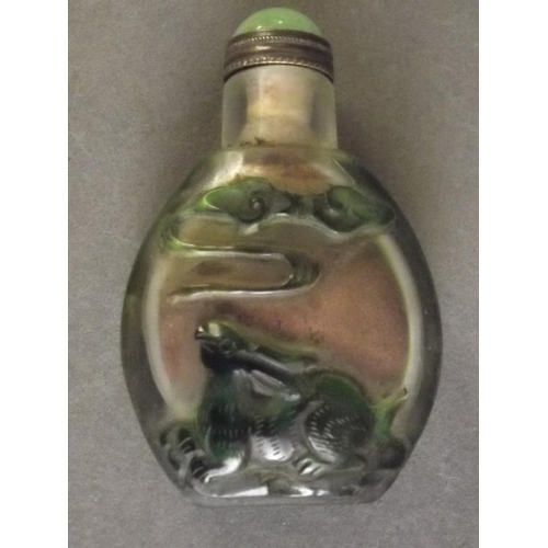 52 - A Peking glass snuff bottle with raised decoration of figures cloud gazing on a green ground, 3