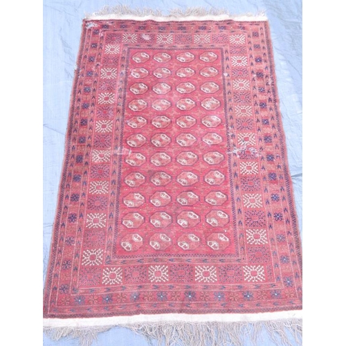 902 - A Persian wool rug with geometric design on a red field, early C20th, 80'' x 50'' (AF)