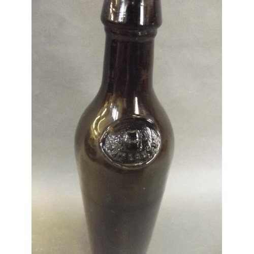 19 - An early C19th olive green glass wine bottle with embossed seal to neck depicting a tankard and P.B.... 