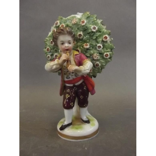 31 - A porcelain figure of a boy piper standing before a tree, gold anchor mark to base, 5