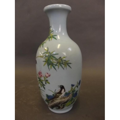 42 - A Chinese porcelain vase decorated with magpies amongst bamboo in bright enamels on a pale blue grou... 