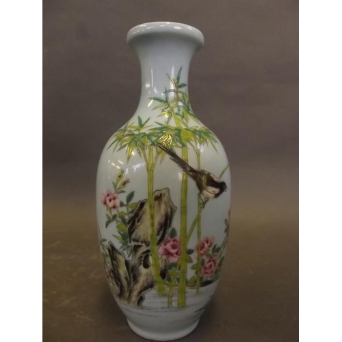 42 - A Chinese porcelain vase decorated with magpies amongst bamboo in bright enamels on a pale blue grou... 