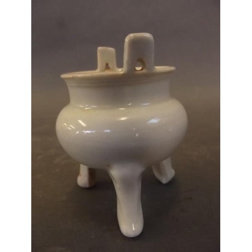 48 - A small Chinese porcelain censer of cauldron form, on shaped tripod legs with pale glaze, 3