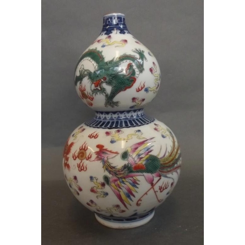 29 - A Chinese porcelain double gourd vase painted in bright enamels with a dragon and phoenix chasing th... 