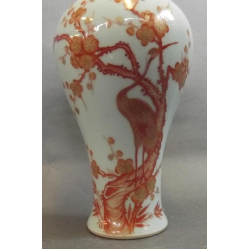 42 - A Chinese porcelain baluster vase decorated in red and gilt with a crane perched in a flowering tree... 