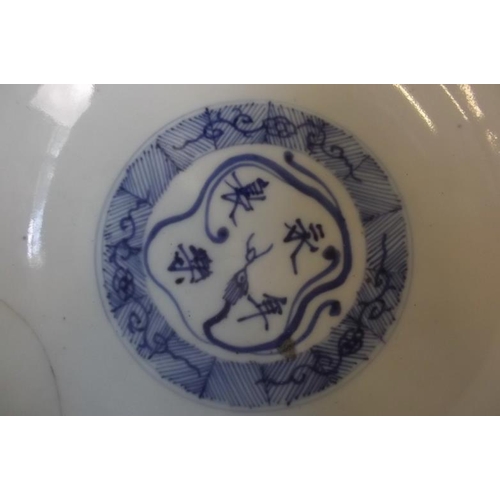 47 - An Oriental blue and white bowl decorated with a landscape and calligraphy, the interior with charac... 