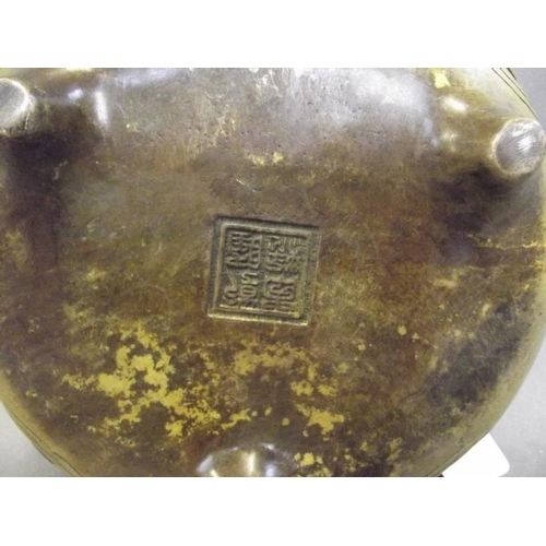 50M - A Chinese bronze censer with twin rope twist handles and Islamic calligraphy decoration, on tripod s... 