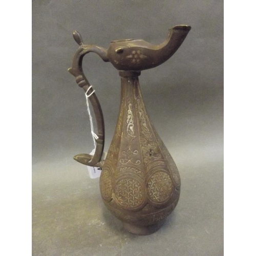 50R - A Middle Eastern bronze ewer/lamp with inlaid copper and silver decoration, with Islamic calligraphy... 