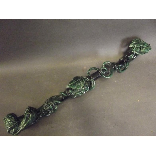 50S - A Chinese dark green glazed pottery ruyi in the form of a fruiting vine around bamboo, 19½