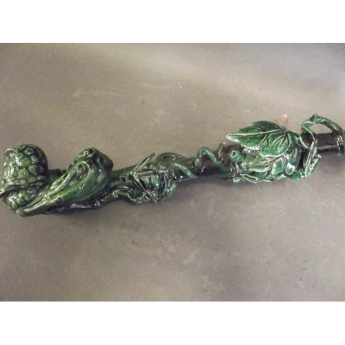 50S - A Chinese dark green glazed pottery ruyi in the form of a fruiting vine around bamboo, 19½