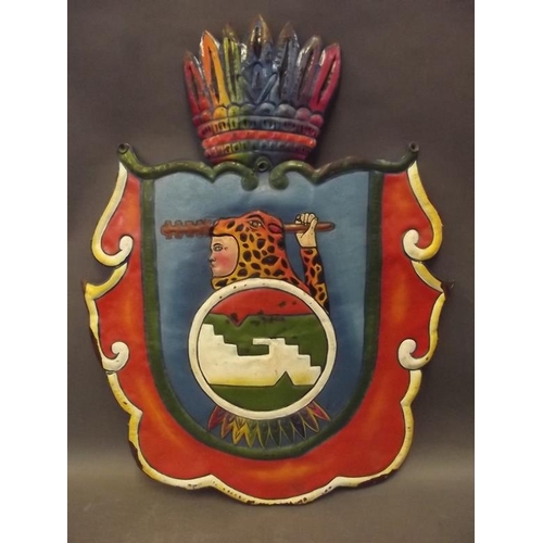 55 - A South/Central American metal shield painted with a coat of arms in bright colours, 22½