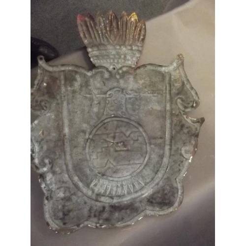 55 - A South/Central American metal shield painted with a coat of arms in bright colours, 22½