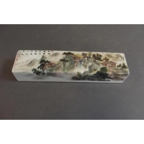 81 - A Chinese porcelain scroll weight decorated in the famille verte palette with houses amongst trees, ... 